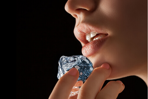 Θεραπείες για τον επιχείλιο έρπητα- Γυναίκα τοποθετεί παγάκι στα χείλι της
