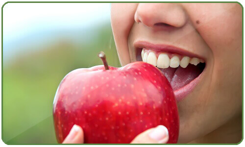 μείωση του λίπους στην κοιλιά- γυναίκα τρώει μήλο