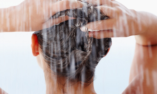 Πιο υγιή μαλλιά - Γυναίκα λούζει τα μαλλιά της