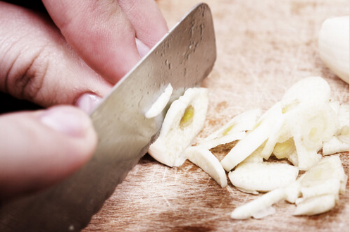 Θεραπείες για τον επιχείλιο έρπητα- Άνδρας κόβει σκόρδο