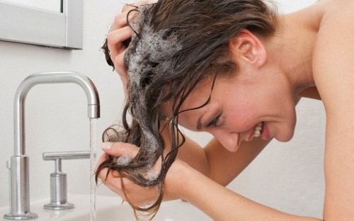 Βότανα που καταπολεμούν την τριχόπτωση - Γυναίκα ξεπλένει τα μαλλιά της