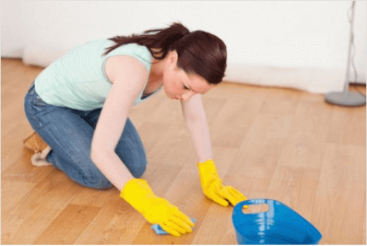 Ξύλινες επιφάνειες - Γυναίκα καθαρίζει ξύλινο πάτωμα