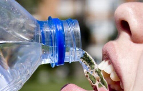 Νερό από πλαστικά μπουκάλια - Άτομο πίνει νερό από πλαστικό μπουκάλι