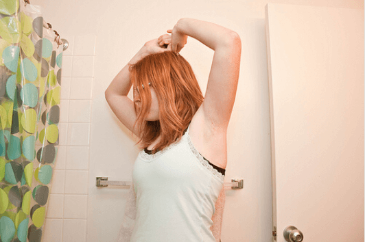 Γυναίκα ελέγχει τη μασχάλη της στο μπάνιο
