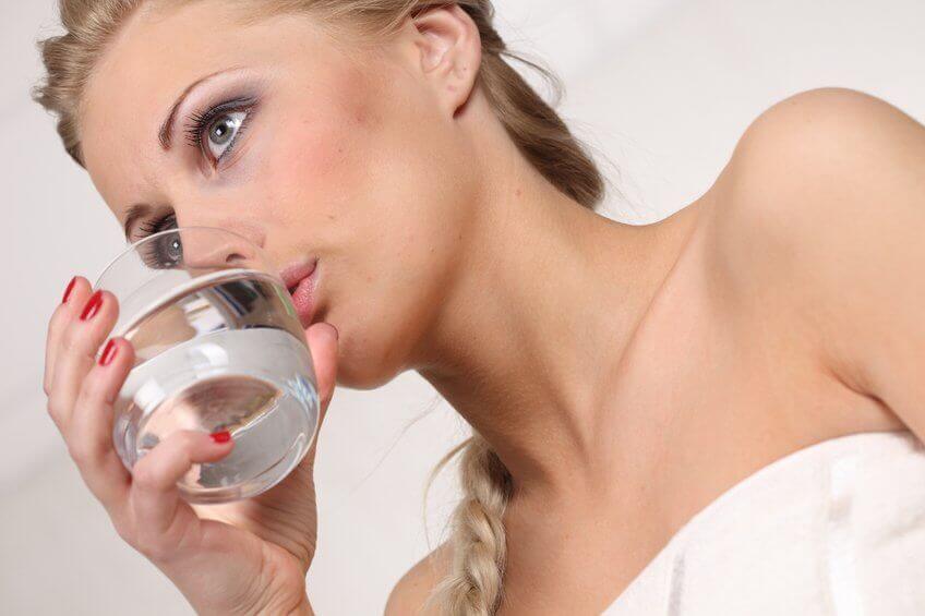 Γυναίκα πίνει ένα ποτήρι νερό