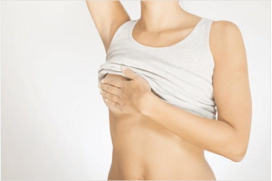 10 προειδοποιητικά σημάδια του καρκίνου του μαστού - Γυναίκα ψηλαφεί το στήθος της