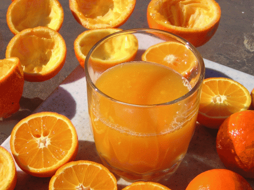 Πορτοκάλια στυμμένα και χυμός σε ποτήρι