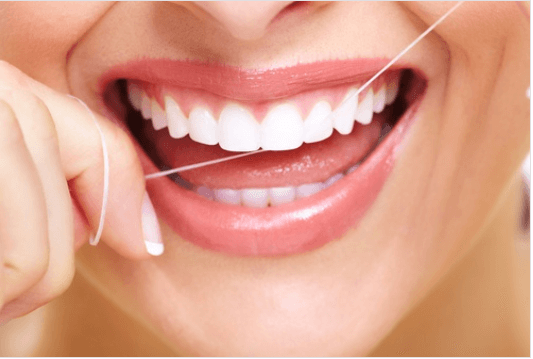 Θεραπείες αντιμετώπισης του πονόδοντου - Γυναίκα καθαρίζει τα δόντια της με οδοντικό νήμα