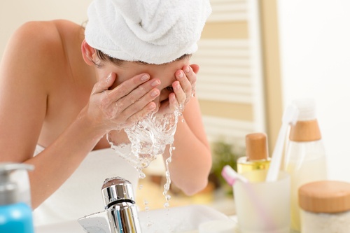 Αφαίρεση του μακιγιάζ - Γυναίκα πλένει το πρόσωπό της με νερό