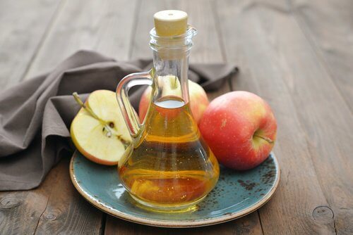 Αφαιρέστε τις κρεατοελιές με φυσικό τρόπο - Μηλόξυδο σε δοχείο και κομμένα μήλα σε πιάτο