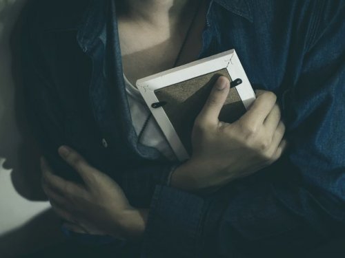 ξεπεράσετε την απιστία Γυναίκα αγκαλιάζει φωτογραφία