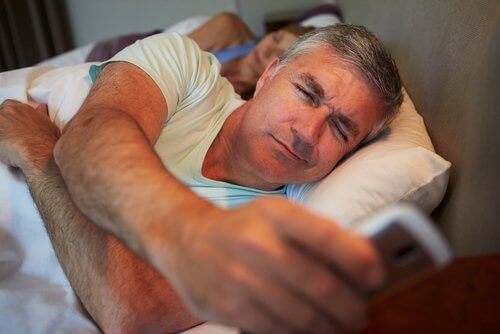 αποφύγετε την αύξηση βάρους: Άντρας με το κινητό στο κρεβάτι