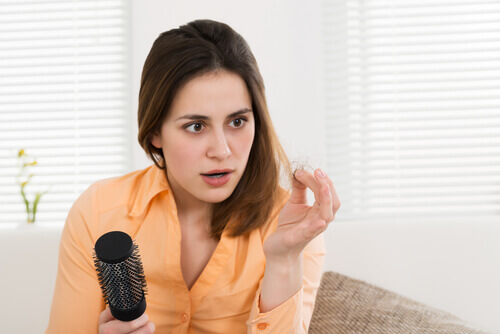Λόγοι που πονούν οι αρθρώσεις - Γυναίκα κοιτά τα μαλλιά της