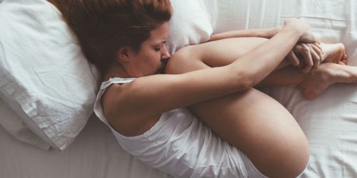 Γυναίκα σε στάση εμβρύου στο κρεβάτι
