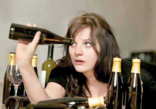 Εξάρτηση από το αλκοόλ - Γυναίκα κοιτά μέσα σε μπουκάλι