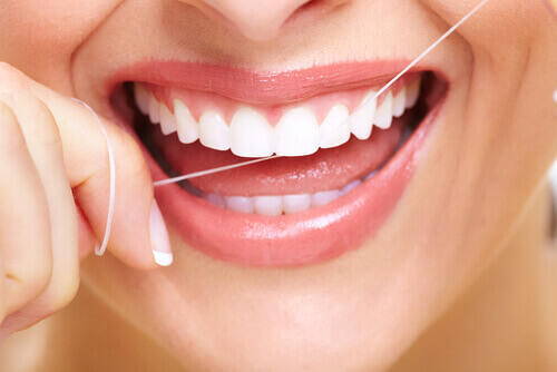 Έξυπνα κόλπα για να καταπολεμήσετε την κακή αναπνοή - Γυναίκα χρησιμοποιεί οδοντικό νήμα