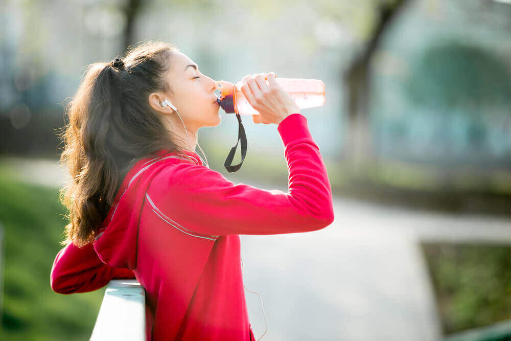 Ποτά που αυξάνουν την αρτηριακή πίεση - Γυναίκα πίνει από παγούρι