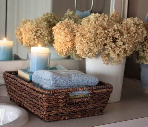 καλάθι μπάνιου με πετσέτες και κερί αναμμένο, διακόσμηση του μπάνιου