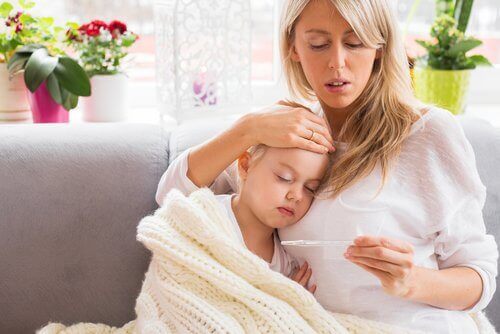 Συμπτώματα της μηνιγγίτιδας - Μητέρα παίρνει τη θερμοκρασία του παιδιού της