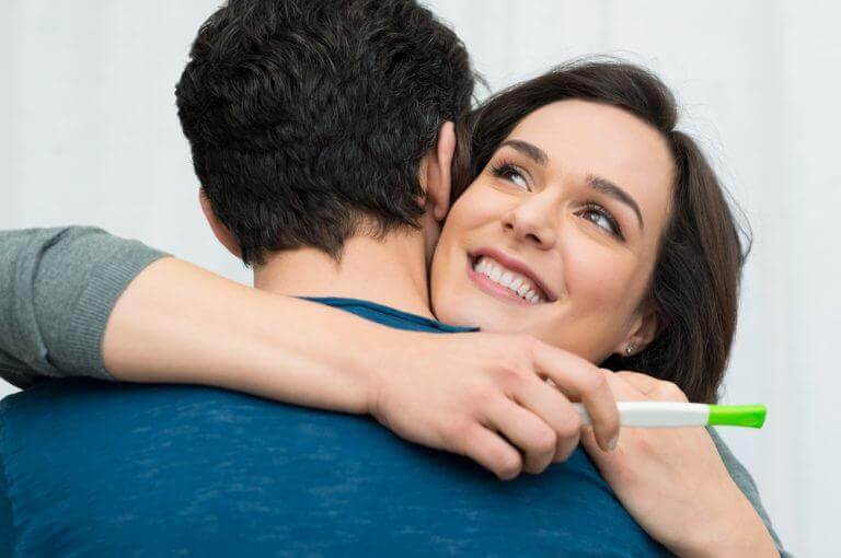 γυναίκα που αγκαλιάζει άνδρα με τεστ εγκυμοσύνης, ερωτήσεις που πρέπει να κάνετε στον/στην γυναικολόγο σας