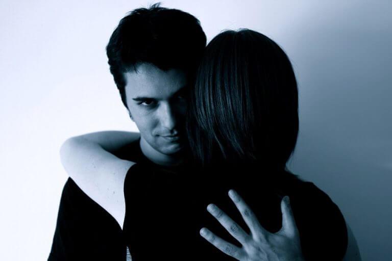 άνδρας που αγκαλιάζει μια γυναίκα, σχέση από φόβο ή ενοχή