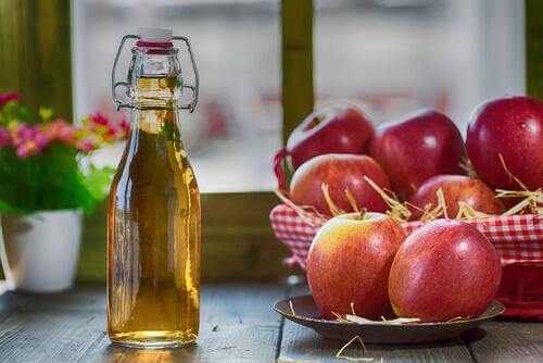 μηλόξυδο σε μπουκάλι και μήλα