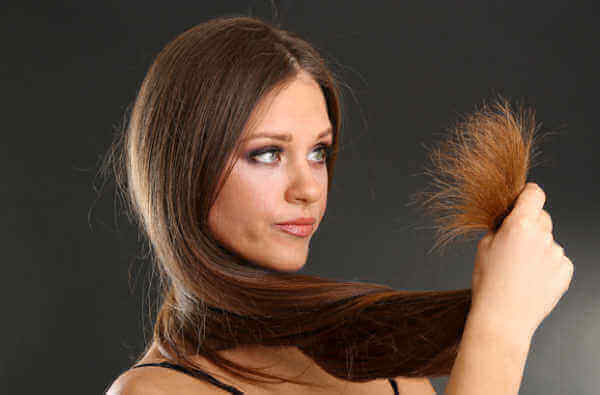 γυναίκα που κοιτάζει τις άκρες των μαλλιών μεταξένια μαλλιά