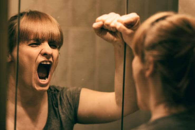 γυναίκα που φωνάζει μπροστά σε καθρέφτη- κλειδιά για να ξεπεράσετε τον συναισθηματικό πόνο