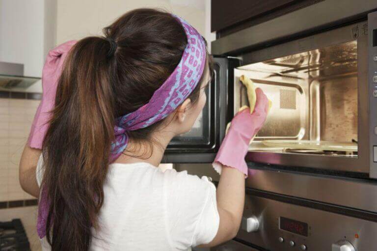 Δυσάρεστες οσμές - Γυναίκα καθαρίζει φούρνο μικροκυμάτων