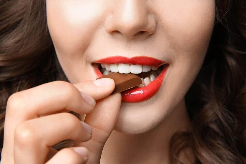 γυναίκα που τρώει ένα κομμάτι σοκολάτα, αδυνάτισμα χωρίς πείνα