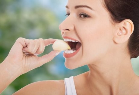 Αντιμετώπιση της υπέρτασης - Γυναίκα τρώει ολόκληρο σκόρδο