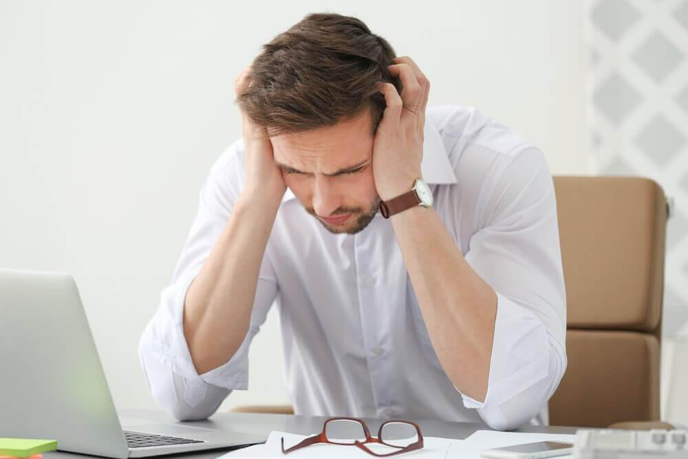 Αιτίες πονοκεφάλων - Άνδρας στο γραφείο με πονοκέφαλο