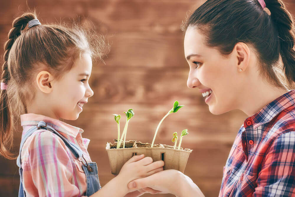 μητέρα με κόρη που της δίνει ένα φυτό- σούπερ μαμά