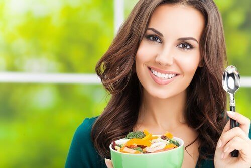 Γυναίκα κρατάει μπολ με λαχανικά, φαγητό και άσκηση