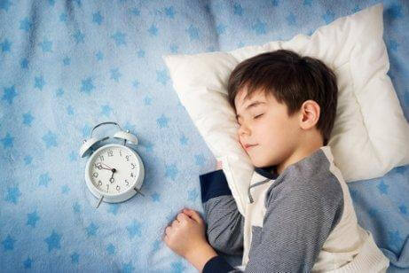 Παιδί που κοιμάται πλάι σε ξυπνητήρι αργά για ύπνο