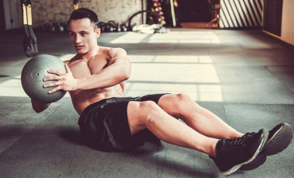 Άνδρας κάνει ασκήσεις με μπάλα γυμναστικής