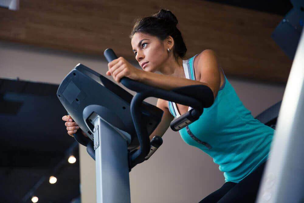 Ασκήσεις που ίσως δε σας βοηθήσουν να χάσετε βάρος - Γυναίκα κάνει ποδήλατο στο γυμναστήριο
