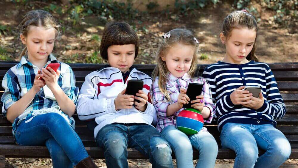 Παιδιά κοιτούν τα κινητά τους τηλέφωνα