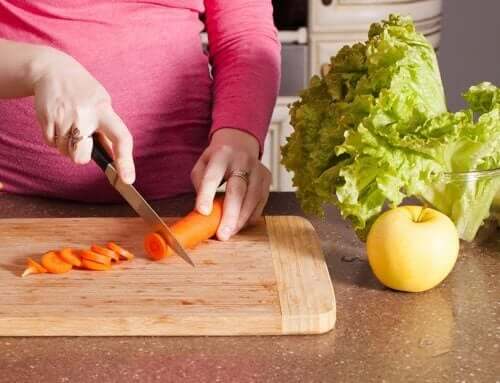 Έγκυος γυναίκα κόβει λαχανικά