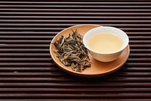 Λευκό τσάι σε μπολ και φύλλα τσαγιού