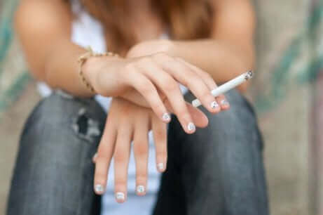 Κοπέλα κρατά τσιγάρο στο χέρι