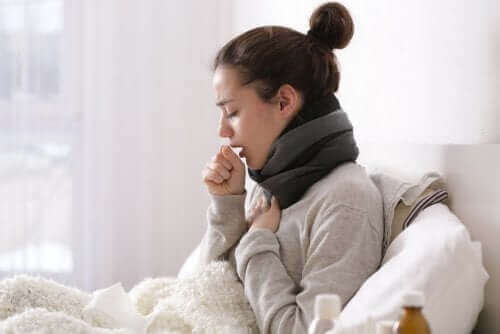 Γυναίκα στο κρεβάτι βήχει-  για να ξεπεράσετε το κρυολόγημα