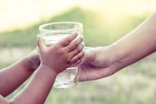 Γυναίκα δίνει ποτήρι με νερό σε παιδί