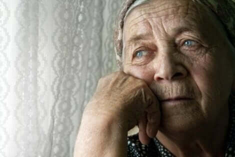 Ηλικιωμένη γυναίκα κοιτά από το παράθυρο