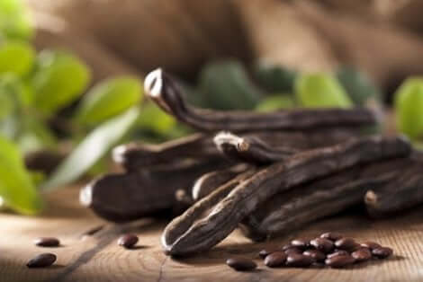 Λοβοί και καρποί χαρουπιού πάνω σε τραπέζι