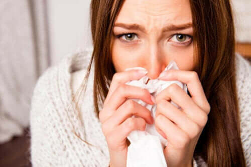 Γυναίκα κρατά μαντήλι στη μύτη της- εξαπλώνεται η γρίπη