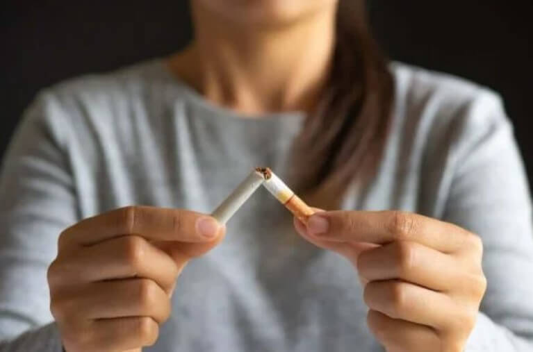 γυναίκα κόβει τσιγάρο με Τσίχλες νικοτίνης