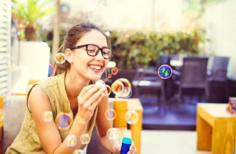 γυναίκα παίζει με σαπουνόφουσκες