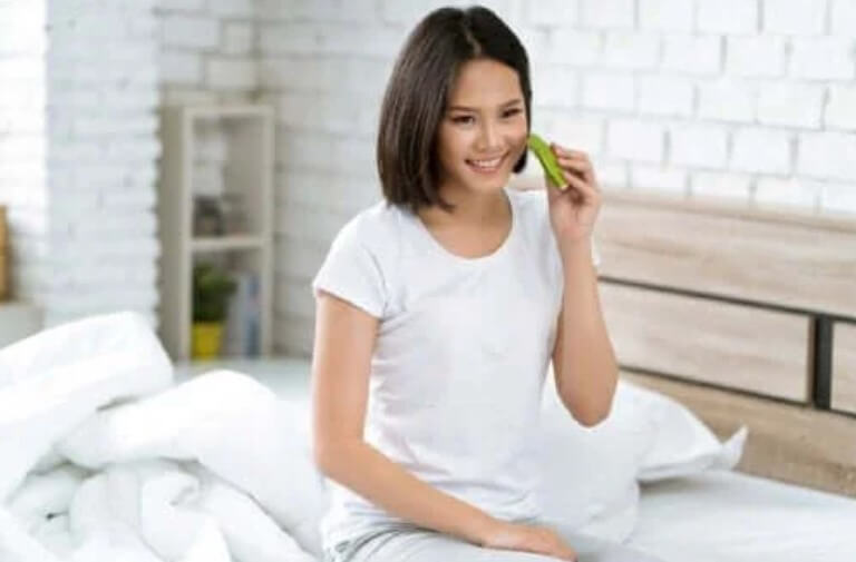 γυναίκα τρίβει αλόη βέρα στο πρόσωπό της