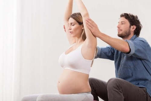 Άνδρας βοηθά έγκυο σε ασκήσεις αναπνοής